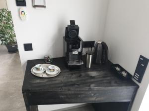 a table with two cups and a coffee maker at FeWo Püttlingen in Püttlingen