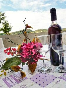 einen Tisch mit zwei Gläsern und einer Flasche Wein in der Unterkunft Apartmani Olivera 2 in Rab