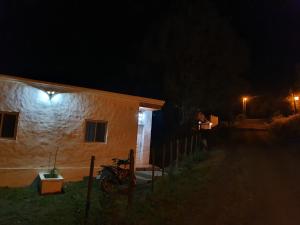 una casa por la noche con una moto estacionada al lado en Casas de Raco in 
