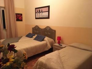 sypialnia z 2 łóżkami i zdjęciem na ścianie w obiekcie Dimora Rossetti w mieście Volterra