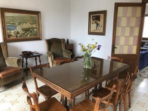 un comedor con una mesa con sillas y un jarrón de flores en Cal Mestre, en Castellfollit de la Roca