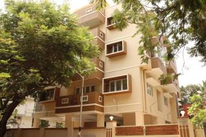 een gebouw met bomen ervoor bij Phoenix Serviced Apartment - Sri Illam in Chennai