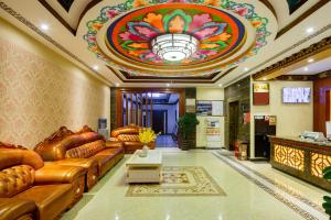 a lobby with brown leather couches and a stained glass ceiling at Floral Hotel · Shangri-la Blue Sky in Shangri-La