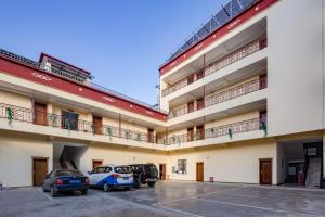 a large building with cars parked in a parking lot at Floral Hotel · Shangri-la Blue Sky in Shangri-La