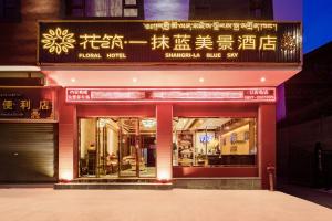 a store front of a building with writing on it at Floral Hotel · Shangri-la Blue Sky in Shangri-La