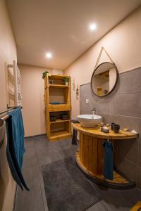 La salle de bains est pourvue d'un lavabo et d'un miroir. dans l'établissement Gite Le chataignier, à Luttenbach-près-Munster