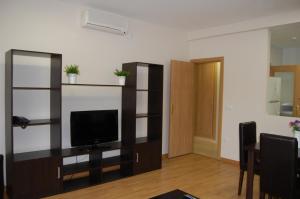 ein Wohnzimmer mit einem Flachbild-TV auf einem Regal in der Unterkunft Aparthotel Encasa in Madrid