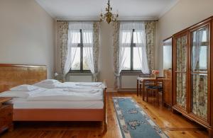 1 dormitorio con 1 cama, escritorio y ventanas en Pałac w Orli - pokoje, restauracja, en Koźmin