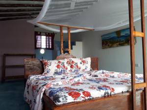 a bedroom with a bed with a floral comforter at Jua Peponi in Michamvi