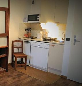 a small kitchen with a stove and a chair at Les 3 marmottes- le Solaret in Bourg-Saint-Maurice
