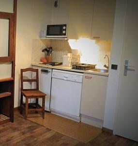 cocina pequeña con fogones y silla en Les 3 marmottes- le Solaret, en Bourg-Saint-Maurice