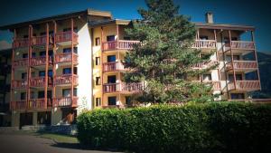 ein großes Apartmenthaus mit einem Baum davor in der Unterkunft Les 3 marmottes- le Solaret in Bourg-Saint-Maurice