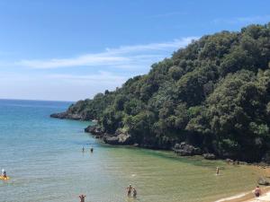 a group of people standing in the water at a beach at Grand Hotel Il Ninfeo in Gaeta
