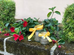two mason jars with yellow bows and red flowers at Grand Hotel Il Ninfeo in Gaeta