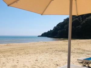 a beach with an umbrella and the ocean at Grand Hotel Il Ninfeo in Gaeta