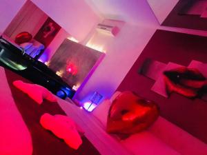 a bedroom with red lighting and red lips on a bed at Bed Cinecitta’ in Rome