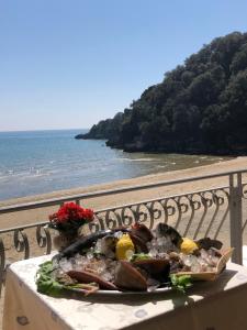 a plate of food on a table next to the ocean at Grand Hotel Il Ninfeo in Gaeta
