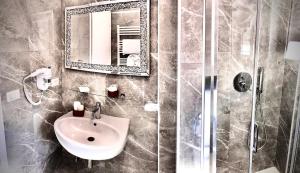 a bathroom with a sink and a mirror and a shower at Bed Cinecitta’ in Rome