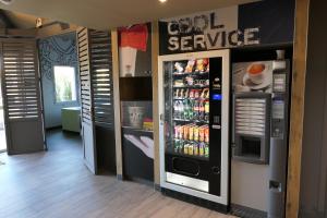 uma máquina de venda automática de refrigerantes com um sinal de serviço frio em Ibis Budget Perigueux Boulazac em Boulazac