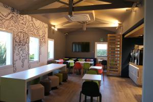 - un restaurant avec des tables et des chaises dans une salle dans l'établissement Ibis Budget Perigueux Boulazac, à Boulazac