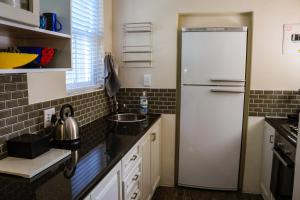 a kitchen with a white refrigerator and a sink at Erinvale Garden cottage in Somerset West +13 photos