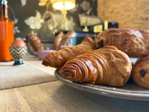 un plato de cruasanes y bollería en una mesa en La Clef des Songes B&B de charme - Sarlat Centre - Parking gratuit - Piscine et espace bien-être à 400mètres, en Sarlat-la-Canéda