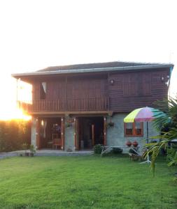 a house with an umbrella in front of it at เฮือนฮอมคำโฮมสเตย์(Huanhomkham homestay) in Chiang Mai