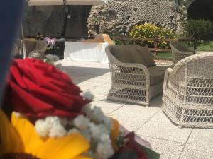a group of wicker chairs and a table with a man in the background at Grand Hotel Il Ninfeo in Gaeta