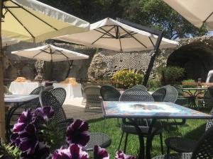 a group of tables and chairs with umbrellas at Grand Hotel Il Ninfeo in Gaeta