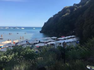 a beach with umbrellas and people in the water at Grand Hotel Il Ninfeo in Gaeta