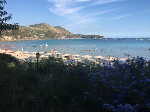 a beach with umbrellas and people in the water at Grand Hotel Il Ninfeo in Gaeta