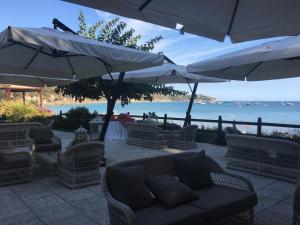 a patio with a couch and umbrellas and the ocean at Grand Hotel Il Ninfeo in Gaeta