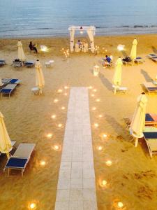 a beach with chairs and umbrellas on the sand at Grand Hotel Il Ninfeo in Gaeta
