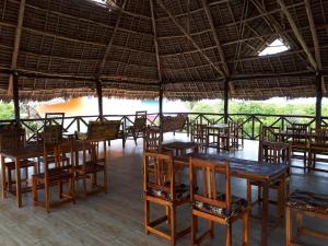 a group of tables and chairs in a restaurant at Jua Peponi in Michamvi