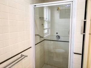 a shower with a glass door in a bathroom at Erinvale Garden cottage in Somerset West