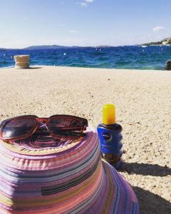 a pair of sunglasses sitting on a towel on the beach at Apartments Gordana in Zaboric