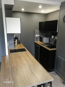 - une cuisine avec un comptoir en bois dans l'établissement Appartement Le 146 Bis, avec Parking, à Rennes