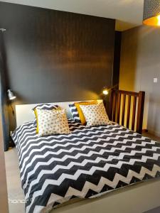 a bedroom with a black and white bed with yellow pillows at Appartement Le 146 Bis, avec Parking in Rennes