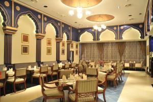 a restaurant with tables and chairs in a room at Mysore County Retreat in Mysore