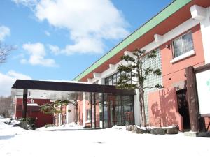a building with a black awning in the snow at Iwanai Kogen Hotel in Iwanai