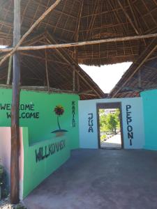 a large building with a door with a palm tree on it at Jua Peponi in Michamvi