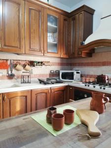 a kitchen with wooden cabinets and a counter top at Villa Santa Elena B&B - Country Home Holiday in Sala Consilina