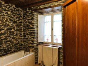 a bathroom with a bath tub and a window at Casa Do Bosque in Cabañas