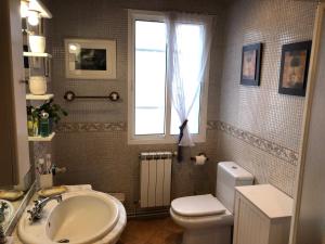 a bathroom with a sink and a toilet and a window at Casa Do Bosque in Cabañas