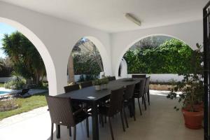 a dining room with a black table and chairs at VILLA LOS TRES SOLES in Les tres Cales