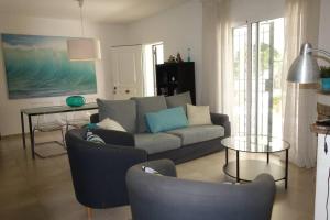 a living room with a couch and chairs and a table at VILLA LOS TRES SOLES in Les tres Cales