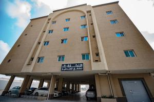un gran edificio con coches estacionados frente a él en Al Nakhla Aparthotel, en Al Hofuf