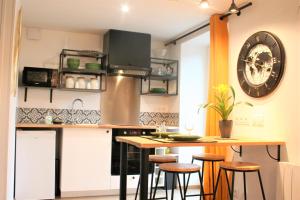una cucina con un bancone e degli sgabelli di Superbe studio entre le port et le centre ville - LIT KING-SIZE, WiFi & NETFLIX gratuit a Saint-Brieuc Altre 23 foto