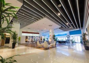 a lobby with chairs and plants in a building at Park Azure Deluxe Home 526 in Baku