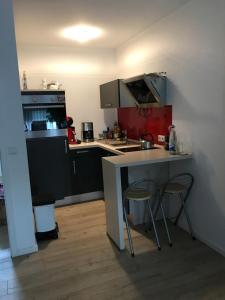 una pequeña cocina con encimera y 2 taburetes en Apartment Friedrich 1201, en Mainaschaff